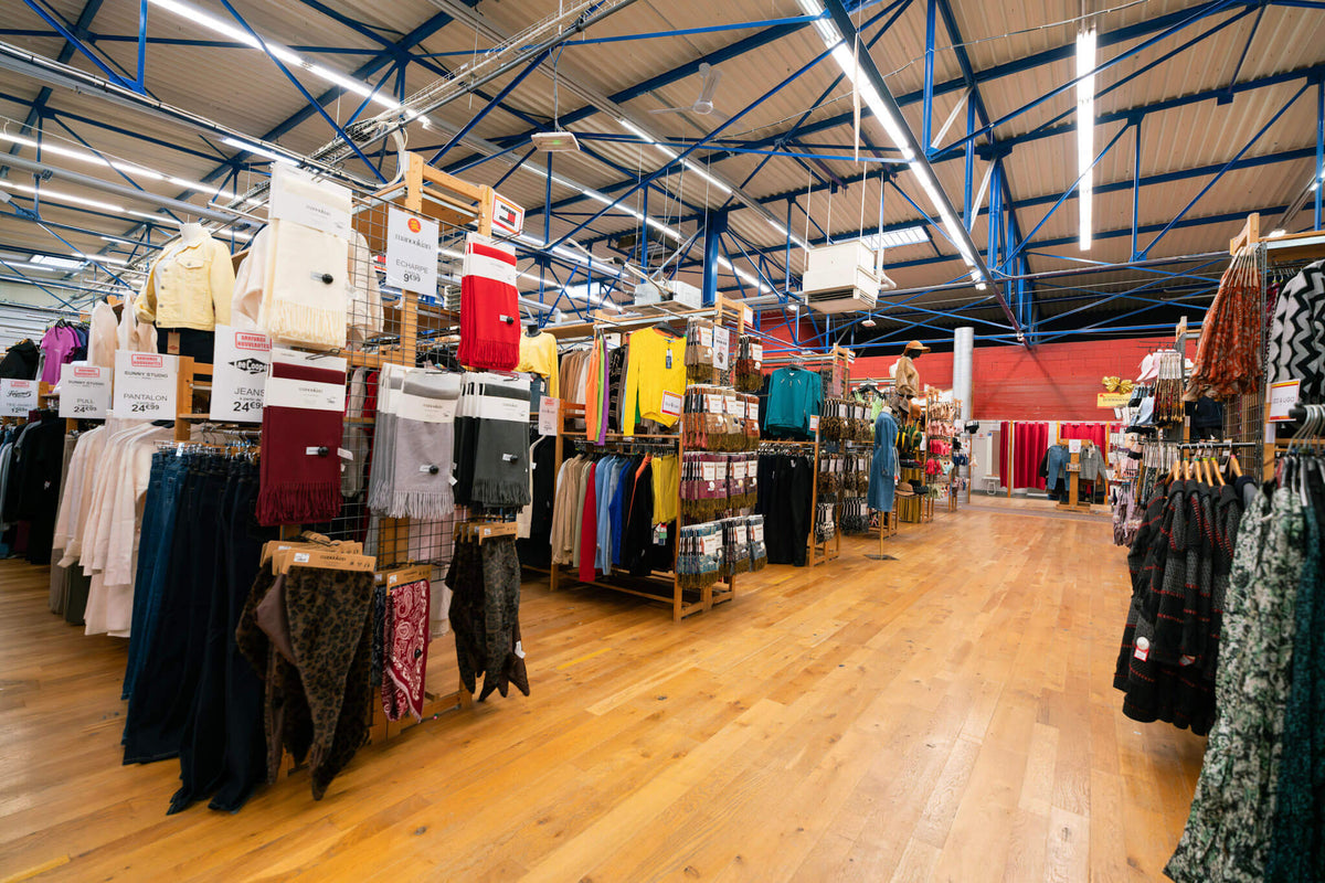 Magasin Au Fil des Marques : rayon femme avec écharpes, pulls et jeans